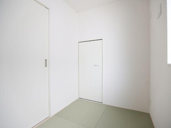 富士見が丘東第6-1号棟の和室|シンプルな白壁と畳が調和した和室です。収納スペースも備え片付けがしやすい設計です。窓から光が差し込み明るい印象の空間となっています。無駄のないデザインが特徴です。