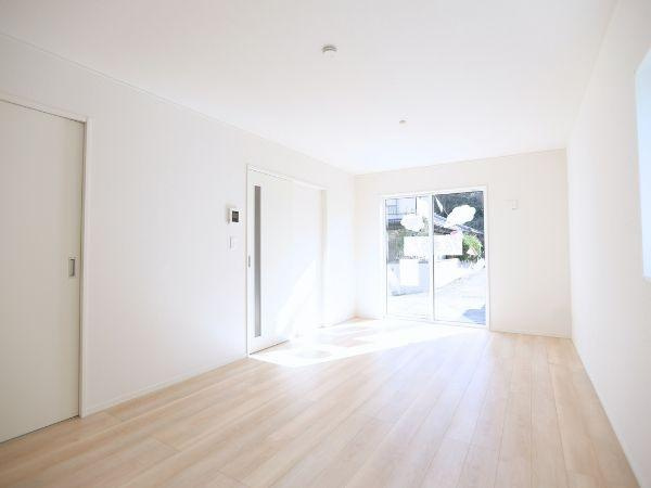 富士見が丘東第6-1号棟の居間・リビング|明るい日差しが差し込むリビングは開放感を感じられる空間です。大きな窓が外と自然につながり室内をさらに広く見せます。シンプルな内装でさまざまなインテリアに調和します。床の色味が温かみをプラスしています。