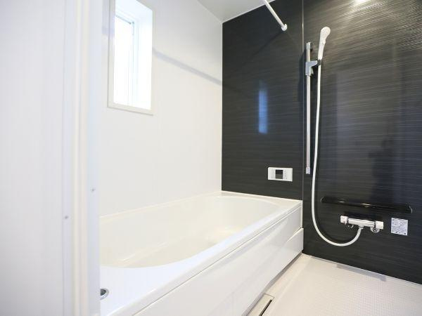 富士見が丘東第6-2号棟の浴室|清潔感のあるバスルームです。シンプルなデザインでお手入れも容易です。窓から採光があり明るい空間です。壁面のアクセントカラーが特徴的です。浴槽とシャワーがすっきりと配置されています。