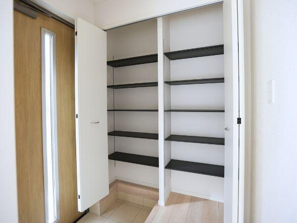 富士見が丘東第6-2号棟の玄関|玄関には収納スペースが豊富に備わっています。すっきりとしたデザインの棚があり小物や靴などを整理できます。扉付きで見た目も整いやすい玄関です。明るい木目調のドアが温かみを与えます。