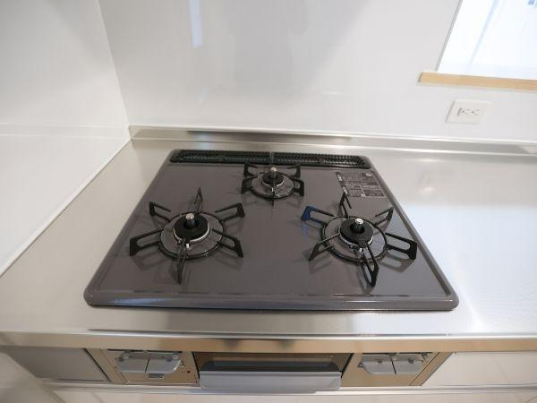 富士見が丘東第6-2号棟のキッチン|三口コンロが備わっており同時に複数の調理が可能です。清潔感のあるステンレス製のカウンターが印象的です。お手入れしやすいフラットな設計で日々の料理もスムーズに進みます。調理スペースもゆとりがあります。