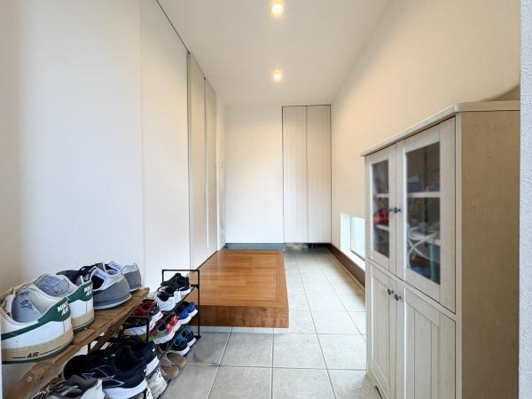 中戸次　中古の玄関|すっきりとした玄関スペースが印象的です。奥に収納スペースがあり、明るい照明で開放感が感じられます。