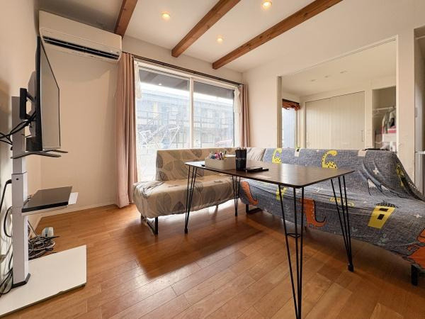 中戸次　中古の居間・リビング|天井の木目調の梁がアクセントとなりリビング全体に落ち着いた雰囲気を演出しています。大きな窓から自然光がたっぷり差し込み明るく開放感のある空間です。