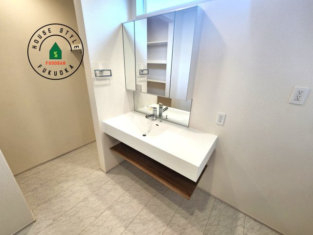 太宰府市青山2丁目第1-1棟（1号棟）の内観：施工例|毎日使うものだから清潔な空間を保ちたい水回り。洗面にはそんな願いを解消させてくれる収納アイデアが満載です。三面鏡の裏側にはキャビネットが現れ小物から背の高い物まで収納できます。