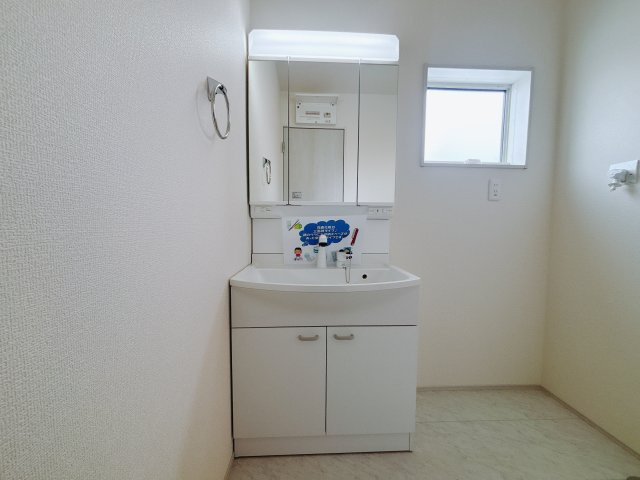 【新築戸建】渋川行幸田第2の独立洗面台|■洗面室（1号棟）｜三面鏡の洗面台は鏡の裏が収納ポケットになっているので、ヘアケア用品や歯ブラシなどでごちゃつきがちな洗面台周りがスッキリ片付きます。　
