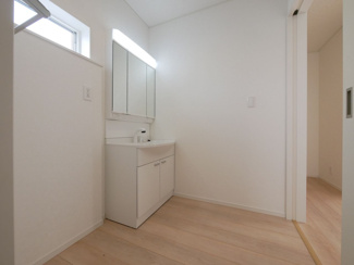 【洗面所】 | 甲斐市竜王 新築戸建 全2棟1号棟 三方角地 オール電化 | 窓付きの洗面室　洗面台は三面鏡仕様