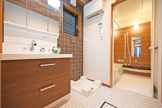 尼崎市琴浦町中古戸建｜4LDK+並列駐車2台可の玄関|1階洗面台は3面鏡裏収納付きのドレッサーを採用しています。小窓も設けているため、電気乾燥機等によりこもる湿気もしっかり排出できます。