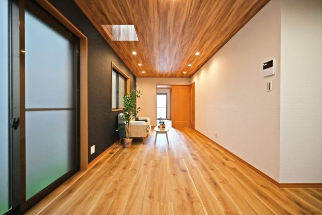 尼崎市琴浦町中古戸建｜4LDK+並列駐車2台可の居間・リビング|1階LDKをダイニング側から正面に撮影した内観写真です。写真のような天井に木目のアクセントクロスを配置することで空間の住み分けや飽きの来ない生活を実現させます。