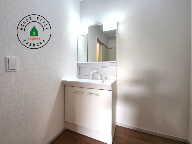 糸島市荻浦3丁目第1-2棟(7号棟)の内観：施工例|毎日使うものだから清潔な空間を保ちたい水回り。洗面にはそんな願いを解消させてくれる収納アイデアが満載です。三面鏡の裏側にはキャビネットが現れ小物から背の高い物まで収納できます。