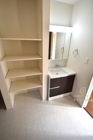 リーブルガーデン  城里町石塚　15期　1の脱衣所|洗面台は洗練されたシンプルなデザインでお手入れも楽です。可動棚付きの収納スペースはタオル、消耗品のストックなどを置いても便利。便利な2WAY出入り口です。
