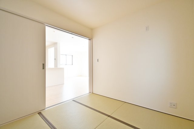 上尾市小敷谷第2全11棟　4号棟の和室|扉を開放すればLDKと一体化する使い勝手の良い続き間設計。キッチンからも目が届くため、家事をしながらお子様のお昼寝や遊び場として安心して活用できます。ライフスタイルに合わせて自在に変化する便利な空間。