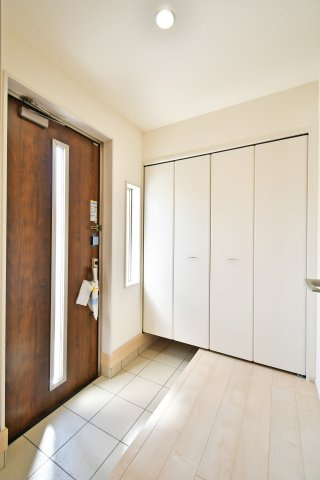 上尾市小敷谷第2全11棟　4号棟の玄関|大容量のシューズボックスを備えた機能的な玄関。家族全員の靴をスッキリ収納でき、常に清潔感のある空間を保てます。スリット窓から差し込む柔らかな光が、毎朝家族を明るく送り出してくれる心地よい設計です。