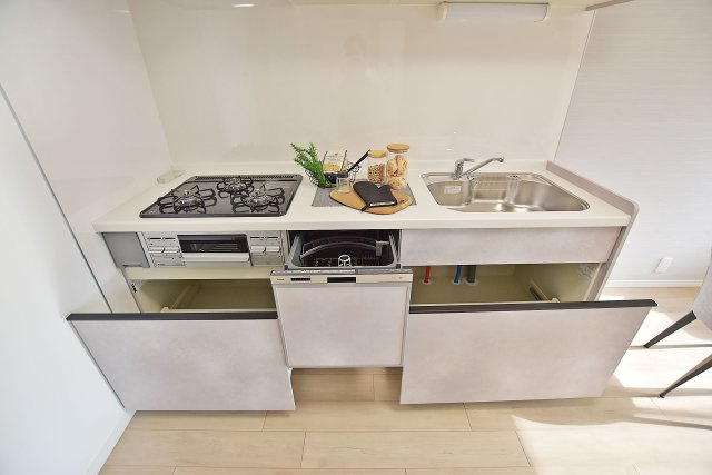 甲子園第八コーポラスA棟のキッチン|天板とワークトップ下いっぱいの収納。食洗器もビルトインしており、効率の良い家事が実現するシステムキッチンです◎