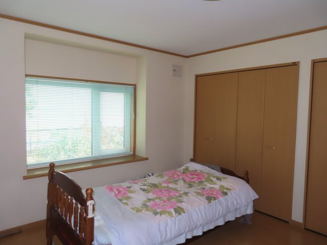 北見市南仲町３丁目５番５号　平家建中古売家外土地１筆の寝室|9.06帖の寝室のフローリングは表面が平らなため、ホコリやゴミが溜まりにくく、拭き掃除や掃除機がけが簡単です。ベッドや家具の配置を頻繁に変えたい場合に、跡が残りにくく、移動がしやすいです。