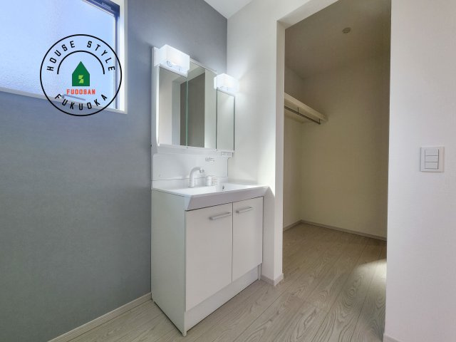 福岡市西区今津第13-1棟（1号棟）の内観：施工例|毎日使うものだから清潔な空間を保ちたい水回り。洗面にはそんな願いを解消させてくれる収納アイデアが満載です。三面鏡の裏側にはキャビネットが現れ小物から背の高い物まで収納できます。