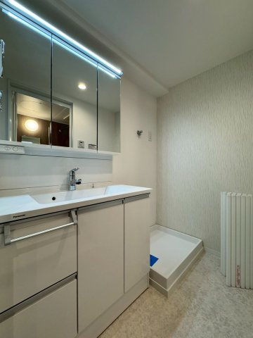 寝屋川東ファミリータウン西4番館の独立洗面台|収納力のある洗面台です。明るくワイドな三面鏡付き！
