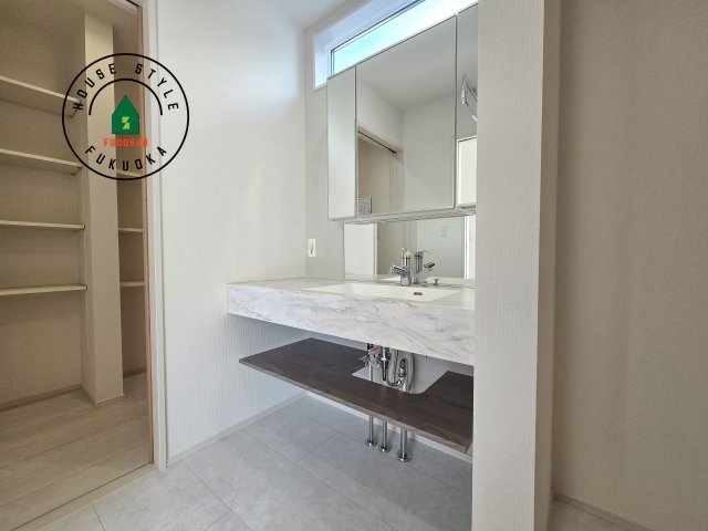 糟屋郡須恵町新原第1-2棟(2号棟)の独立洗面台|毎日使うものだから清潔な空間を保ちたい水回り。洗面にはそんな願いを解消させてくれる収納アイデアが満載です。三面鏡の裏側にはキャビネットが現れ小物から背の高い物まで収納できます。