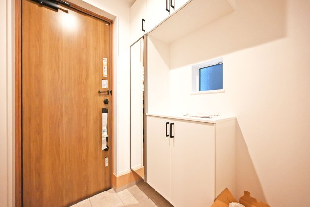 尼崎市大島1丁目新築戸建│南向き5LDK+駐車1台可の玄関|1階玄関をホール側から撮影した内観写真です。玄関にはシューズインクロゼットとシューズボックスがあるので、家族みんなの靴もすっきり収納できます。