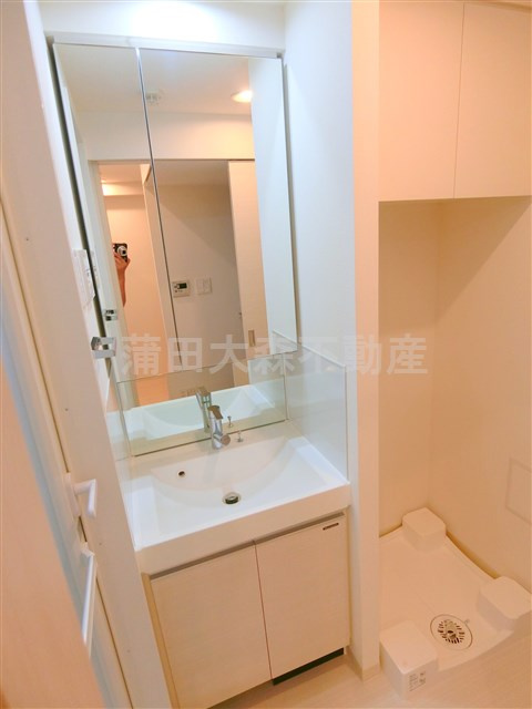 アジールコート蒲田の洗面所|2面鏡の独立洗面台　棚収納付きの洗濯機置き場　洗面脱衣所