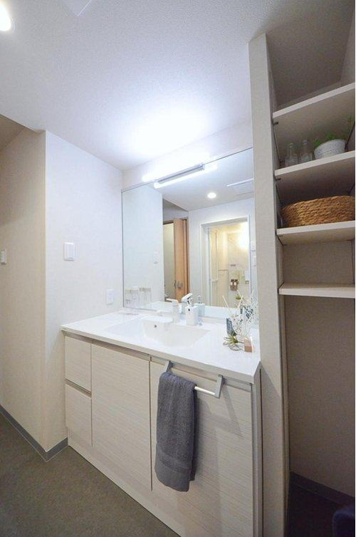 鈴が峰第3住宅2号棟の洗面所|清潔感あふれるシャワー付洗面台と洗面室。収納もある余裕のスペース。