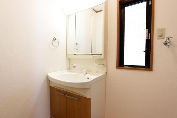 横浜市鶴見区潮田町１丁目の中古一戸建の独立洗面台|洗面台はシンプルで使いやすいデザインです。大きな鏡が設置されており身支度に便利です。収納スペースも備わっているため小物の整理がしやすいです。窓があり通気性が確保されています。