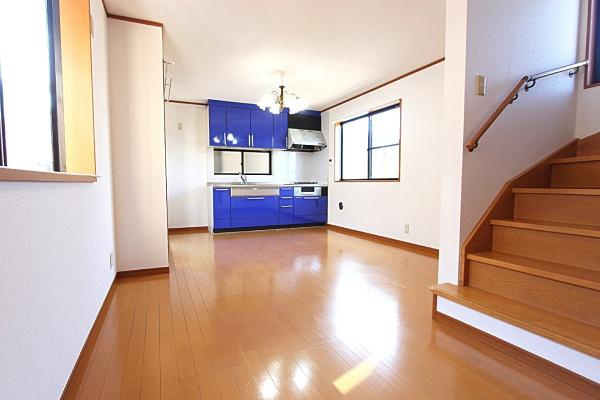 横浜市鶴見区潮田町１丁目の中古一戸建の居間・リビング|明るい日差しが差し込むリビングは広々とした空間が魅力です。ナチュラルなフローリングが清潔感のある印象を与えます。ブルーのキッチンがアクセントとなり室内全体がすっきりとした印象です。