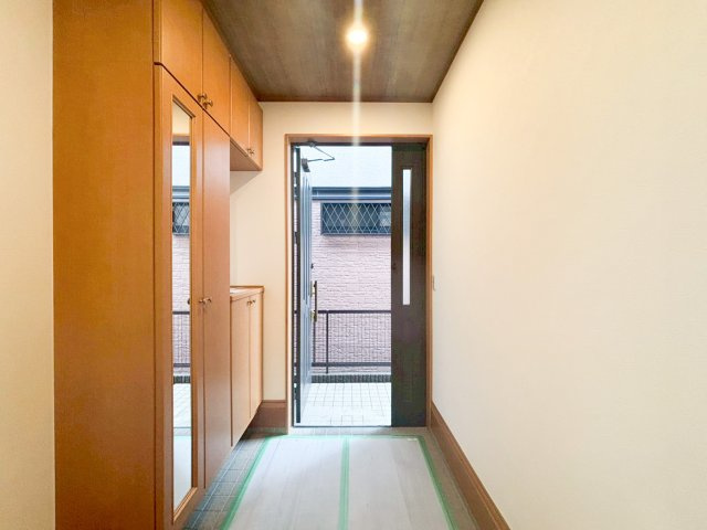 デザイナーズ中古住宅限定1棟！　横浜市神奈川区白幡東町の玄関|木の温もりを感じる清潔感のある玄関。天井までの大型シューズボックスと、姿見付きのトール収納で、家族全員の靴や外出グッズをすっきり収納できます。