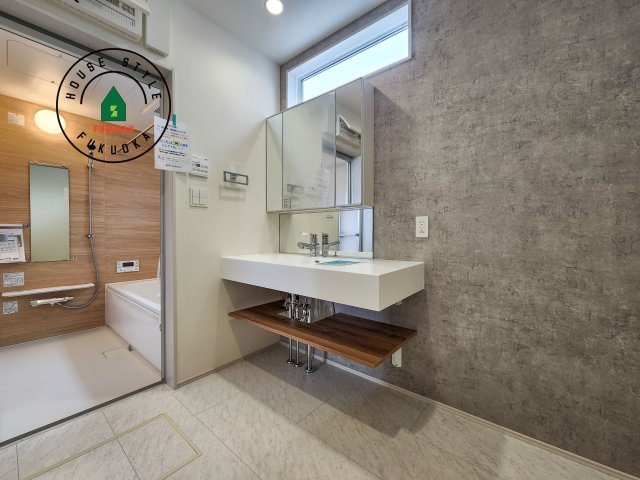 糟屋郡志免町王子2丁目第1-8棟（8号棟）の内観：施工例|毎日使うものだから清潔な空間を保ちたい水回り。洗面にはそんな願いを解消させてくれる収納アイデアが満載です。三面鏡の裏側にはキャビネットが現れ小物から背の高い物まで収納できます。