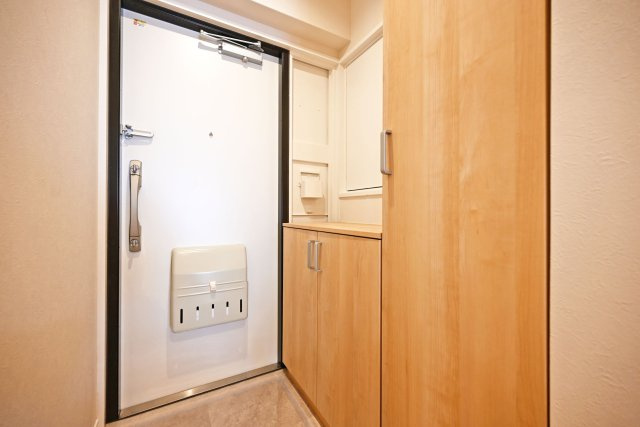 マンション塚口の玄関|玄関には背の低いシューズボックスと、高い収納がございます。ご家族が多い方や、スニーカーの収集が趣味の方も安心の収納量です