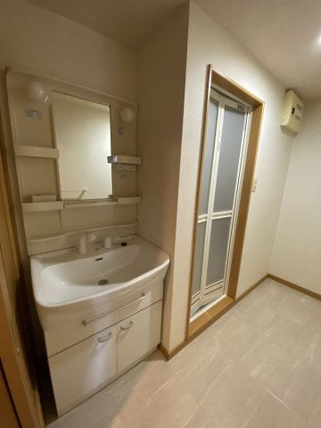 グランパークシーマレジデンスの洗面所|入ってすぐに洗面台があり、その奥に風呂場、洗濯機置き場があります。
