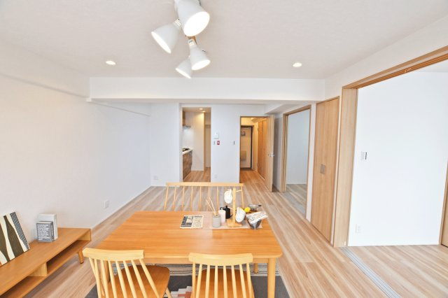 シャルム野中南公園の居間・リビング|キッチンに向かって撮影した写真です。隣接する洋室を開放し一体利用することで大きなスペースを生み出すことができます。来客時には便利ですね。