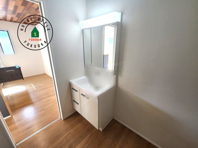 糟屋郡須恵町上須恵第25-2棟（4号棟）の内観：施工例|毎日使うものだから清潔な空間を保ちたい水回り。洗面にはそんな願いを解消させてくれる収納アイデアが満載です。三面鏡の裏側にはキャビネットが現れ小物から背の高い物まで収納できます。