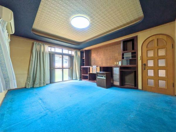 臼杵市大字江無田　戸建ての居間・リビング|天井のデザインが印象的なリビングです。大きな窓から光が差し込み室内が明るい印象です。造り付けの収納棚が壁面に設けられており整理整頓に役立ちます。
