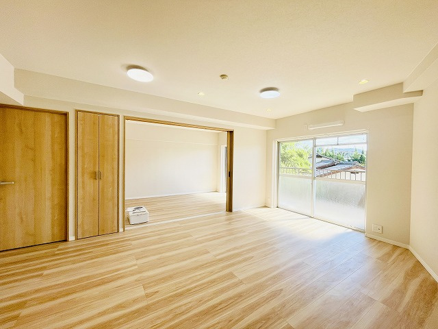 【居間・リビング】 | 三愛シティライフ二日市 | 南東向きのバルコニー側で明るい室内です◎隣りの洋室とつなげると、リビングはさらにゆったり