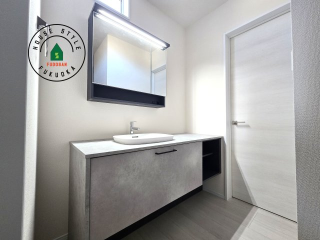 福津市西福間3丁目第1-2棟（1号棟）の内観：施工例|毎日使うものだから清潔な空間を保ちたい水回り。洗面にはそんな願いを解消させてくれる収納アイデアが満載です。三面鏡の裏側にはキャビネットが現れ小物から背の高い物まで収納できます。