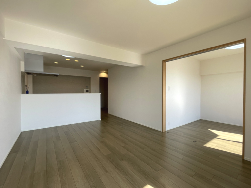 みゆきパークマンションA棟の居間・リビング|圧迫感がなく空間に調和するホワイトキッチン。住まう方の好みでアレンジしやすいシンプルな内装です。