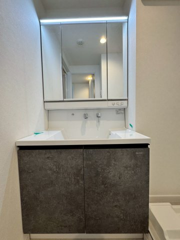 レックスタウン新高弐号館の独立洗面台|リフォーム済みの明るい3面鏡を備えた洗面化粧台です。
