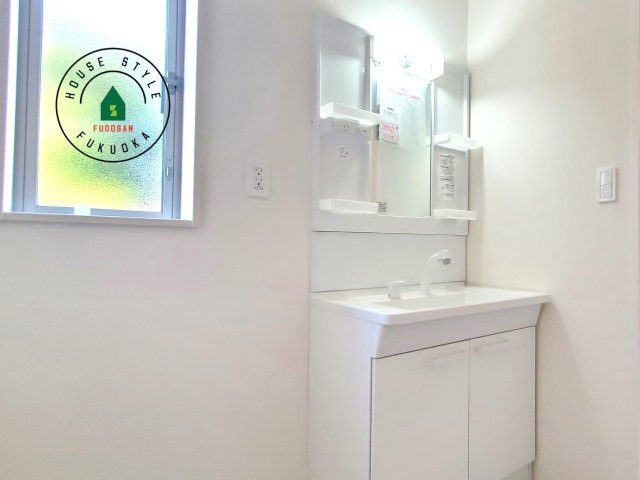 福岡市東区青葉6丁目第1-2棟（A号棟）の内観：施工例|毎日使うものだから清潔な空間を保ちたい水回り。洗面にはそんな願いを解消させてくれる収納アイデアが満載です。三面鏡の裏側にはキャビネットが現れ小物から背の高い物まで収納できます。