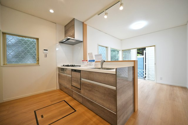 宝塚市今里町中古戸建｜4LDK+駐車1台可のキッチン|1階LDKをキッチンユニット越しに撮影した内観写真です。対面式キッチンを採用しているため視界は広く、ご家族間やご来訪者とのコミュニケーションも一体的に取り易くなっております。