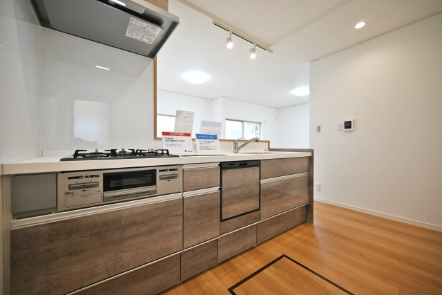 宝塚市今里町中古戸建｜4LDK+駐車1台可のキッチン|1階キッチン奥側から撮影した内観写真です。新調されたシステムキッチンは、浄水器一体型水栓、食器洗い乾燥機などの充実した設備内容です。