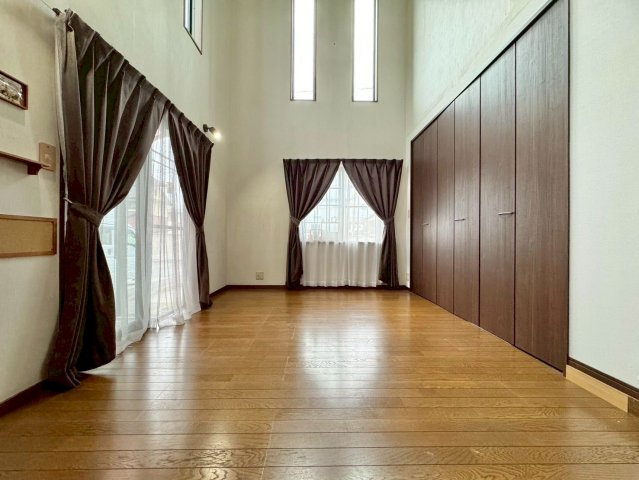 近江八幡市多賀町　中古戸建ての居間・リビング|たくさんの窓と吹抜けの相性がばっちり。高い位置からも陽の光が降り注ぎ、とても開放的な空間を演出します。