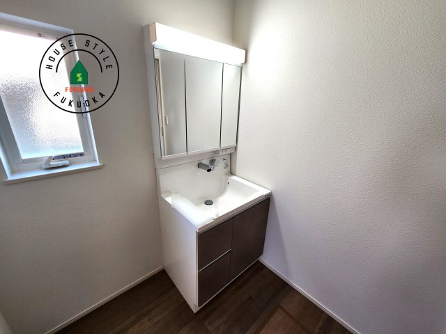 福津市若木台6丁目第2-1棟（1号棟）の内観：施工例|毎日使うものだから清潔な空間を保ちたい水回り。洗面にはそんな願いを解消させてくれる収納アイデアが満載です。三面鏡の裏側にはキャビネットが現れ小物から背の高い物まで収納できます。