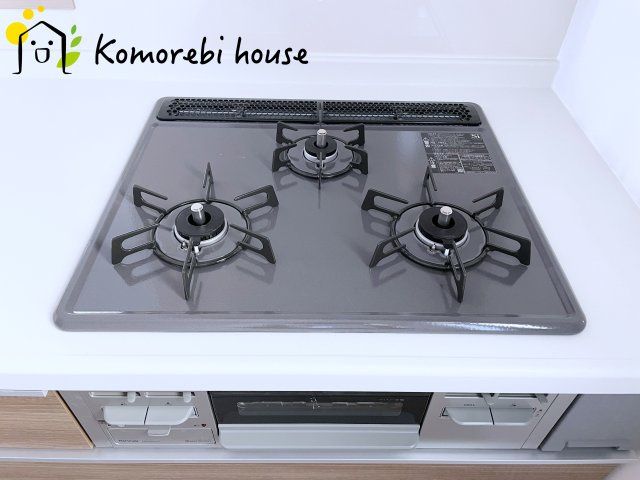 上尾市瓦葺1247番　新築一戸建て　Aのキッチン|同時調理が叶う3口コンロと便利なグリル付き。忙しい朝のお弁当作りも、夕食の複数メニューもスムーズにこなせる頼れる設備です。															