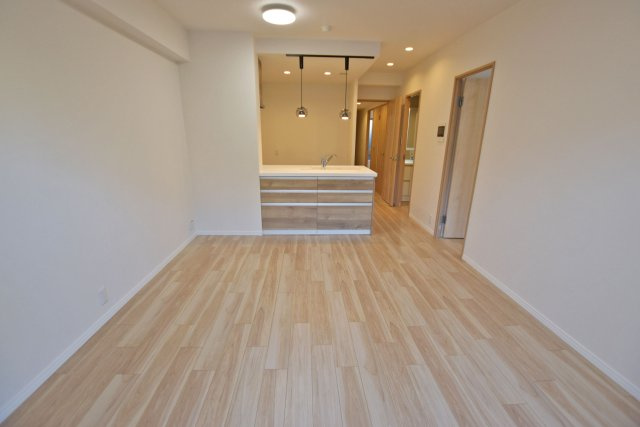 エンゼルクレッセ西難波の居間・リビング|フルフラット対面キッチンにペンダイントライトを施したおしゃれなキッチンを採用◎ダイニングテーブルやソファーを設置しても十分な広さです！