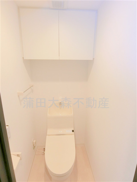 アイルエアポート羽田のトイレ|上部吊り戸棚と窓、温水洗浄便座付きのトイレ