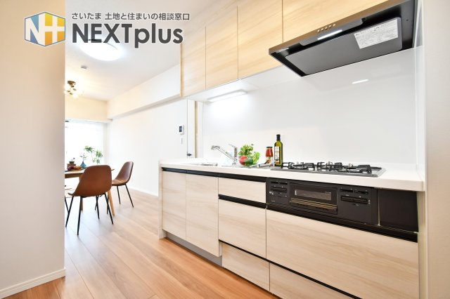 ベルドゥムール春日部のキッチン|白基調の吊戸棚付きシステムキッチンです。上にも下にもたくさん収納出来ますので、別途で食器棚がなくてもたくさん収納する事ができます！ライトもありますので、お料理中の手元もしっかり照らしてくれます。