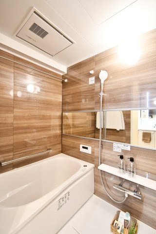 ベルドゥムール春日部の浴室|シックで上品さを感じるバスルームはまるでホテルのような仕上がり。日常から解放できる癒しの空間となります。木目がアクセントになっております！新品ですのでご入居後から気持ちよく入浴頂けます。