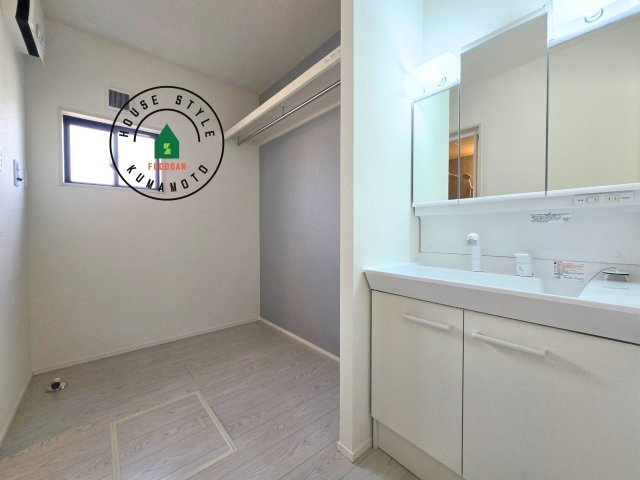 菊池郡大津町大字大林第1-1棟(1号棟)の内観：施工例|毎日使うものだから清潔な空間を保ちたい水回り。洗面にはそんな願いを解消させてくれる収納アイデアが満載です。三面鏡の裏側にはキャビネットが現れ小物から背の高い物まで収納できます。