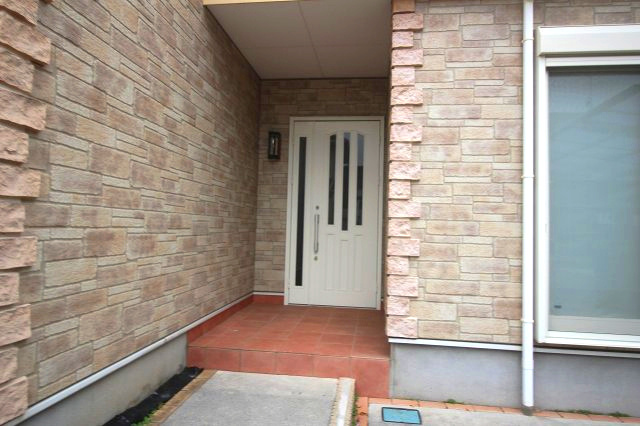 小山市犬塚7丁目の玄関|屋根付きの玄関ポーチで雨の日も濡れずに出入りできます。タイル張りでお手入れしやすく、荷物が多い日も安心の広さです。