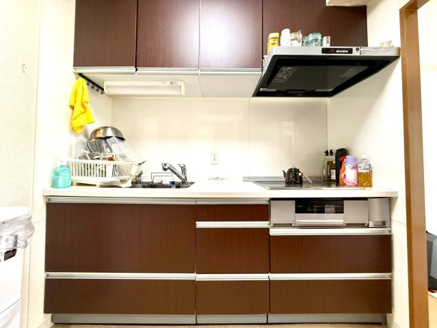 セントヒルズ東浦和のキッチン|ダークブラウンの木目調キッチンが高級感を演出。充実した収納と使いやすい設計で、料理を愉しむ空間に仕上がっています。